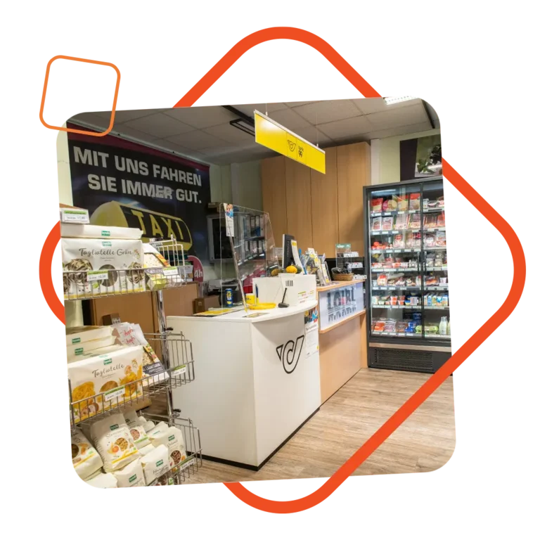 Postschalter im Nah & Frisch Shop der Tankstelle Loibl, mit Post-Logo auf dem Tresen, Produkten im Hintergrund und gut sichtbarem „Post“-Schild über dem Schalter; eingerahmt von einem orangefarbenen grafischen Element.